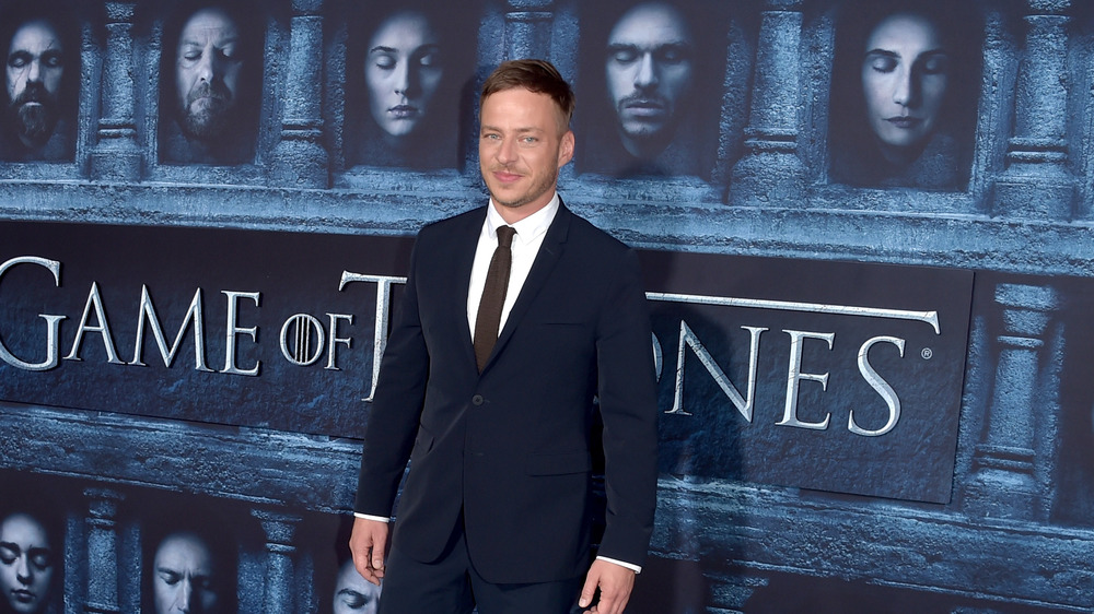 Tom Wlaschiha at the Game of Thrones premiere with the hall of many faces backdrop