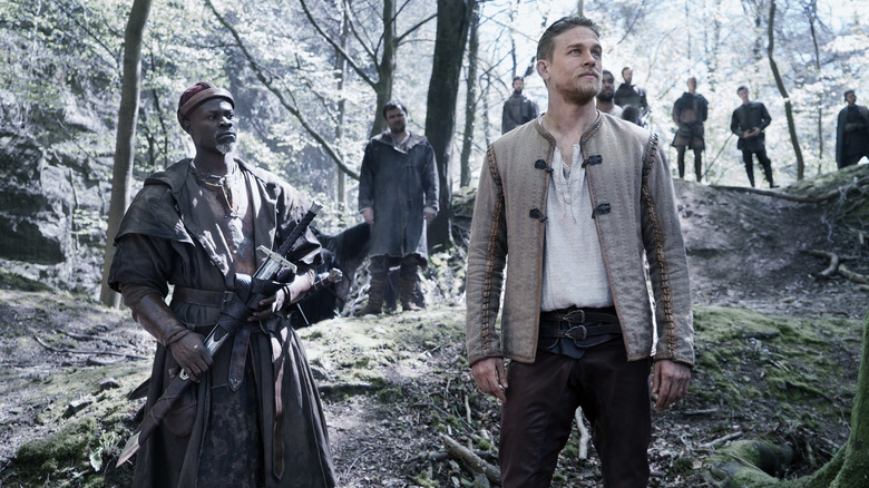 Djimon Hounsou and Charlie Hunnam observing their surroundings