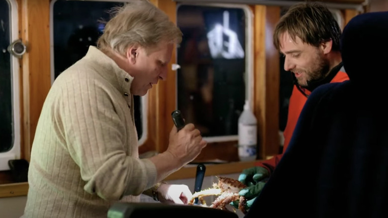 Sig Hansen examining a crab with a light