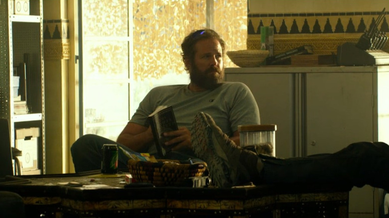 Dave "Boon" Benton sitting in a chair holding a book