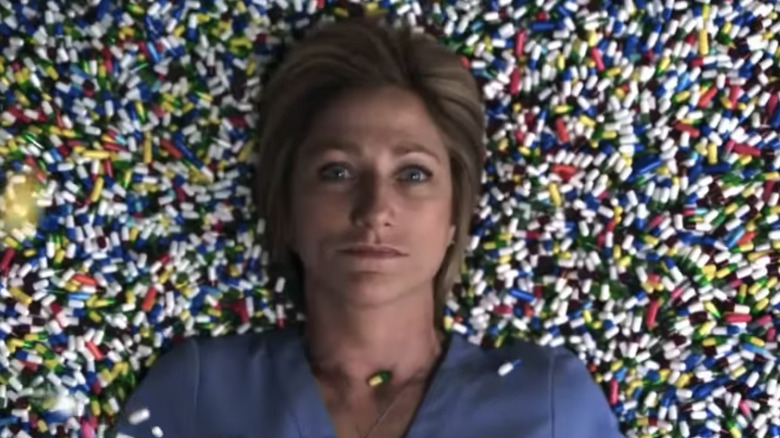 nurse Jackie lying in a bed of pills