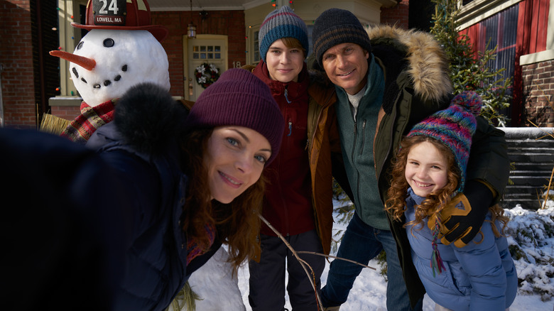 Family pose with a snowman