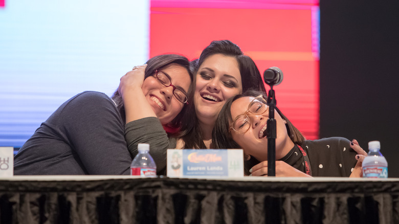 Erica Mendez embraces two of her castmates