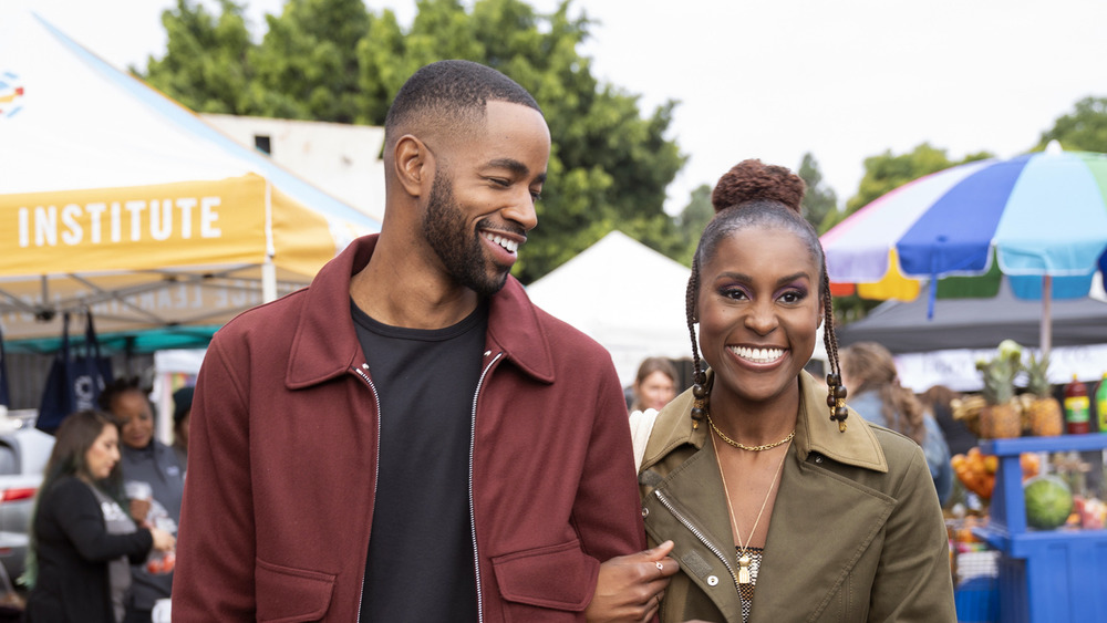 Issa Dee walks through a farmer's market with Lawrence