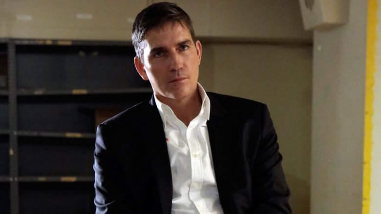 John Reese glowering in suit