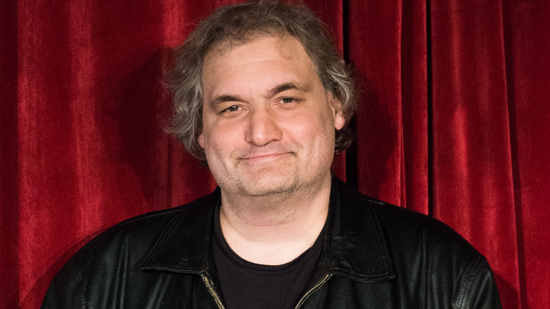 Artie Lange closed smile facing forward red background