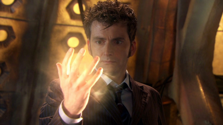 Tenth Doctor looks at his glowing hand