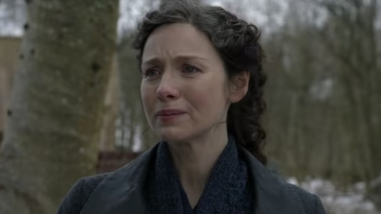 Outlander Caitríona Balfe stands near trees