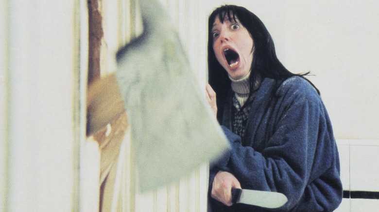 Wendy Torrance screaming as an ax breaks through the door in front of her