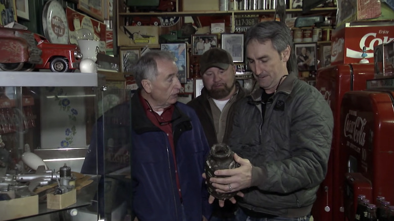 Mike Wolfe looking at antique jar