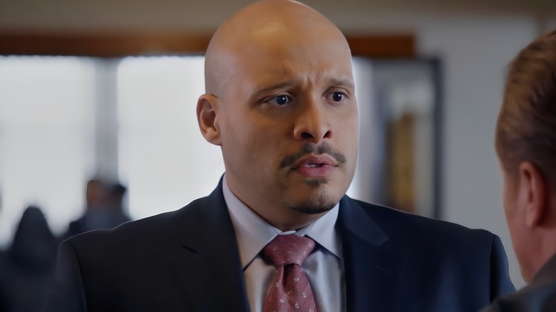 Joe Cruz wearing blue blazer and red tie