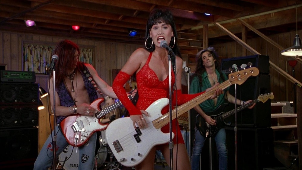 Tia Carrere as Cassandra playing bass in a red dress in Wayne's World