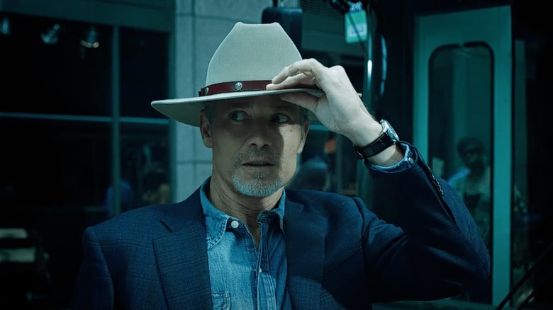 Timothy Olyphant grabbing cowboy hat