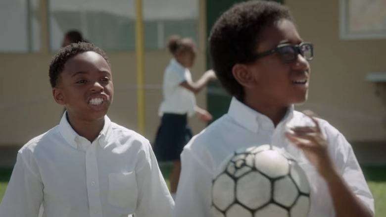 Young Uzo and Chidi playing soccer