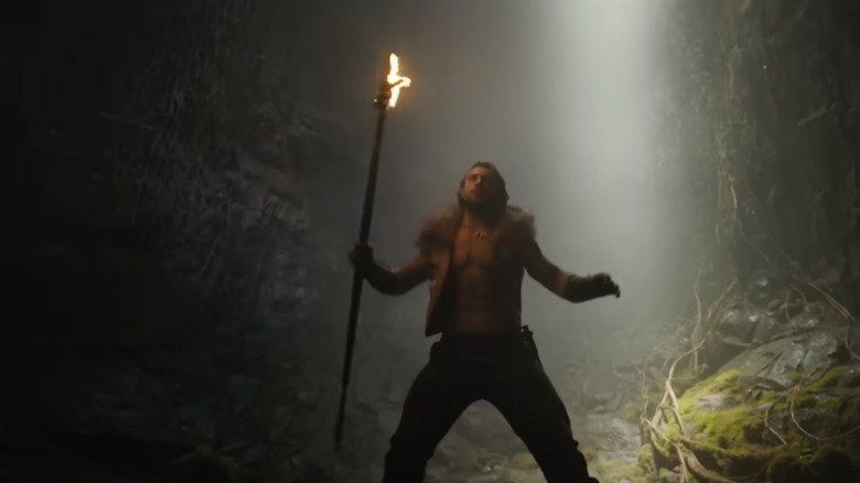 Kraven standing in a cave with a spear