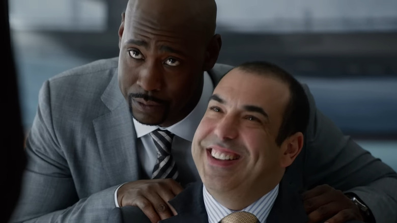 Jeff Malone rubbing Louis Litt's shoulders