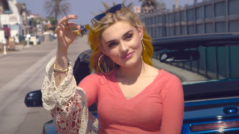 Meg Donnelly shakes a set of keys in the music video for Smile