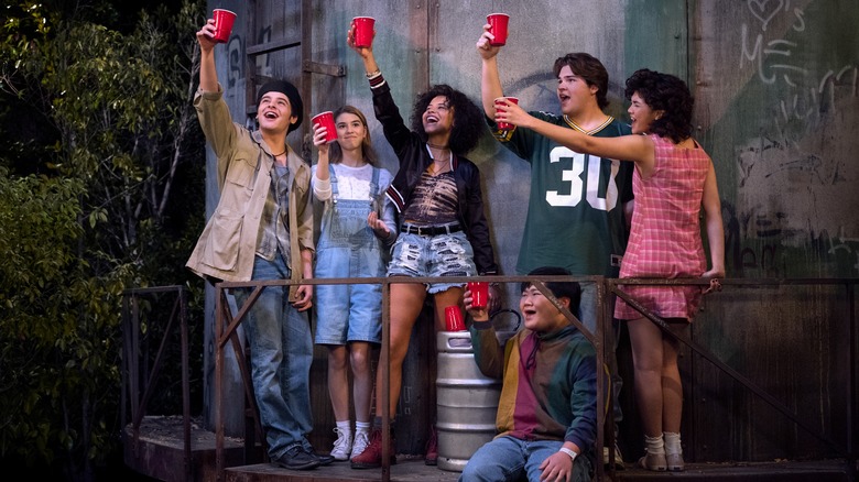 Leia and her friends holding red cups in the air