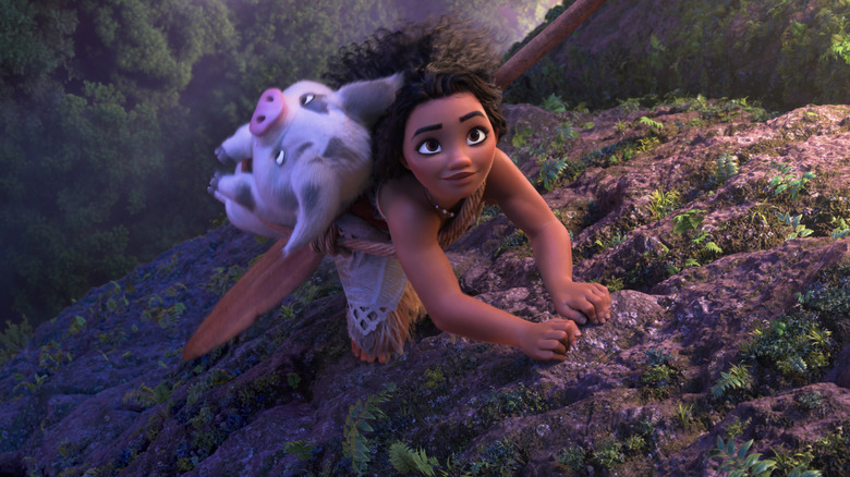 Moana climbing a cliff with Pui strapped to her back