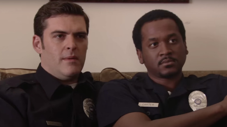 Jerry Minor and Jay Johnston as cops sitting on couch 