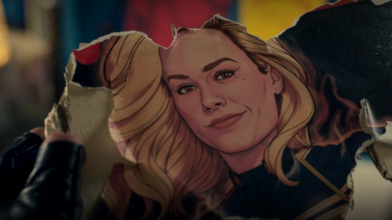 Captain Marvel looks at a fragmented poster of herself in Ms. Marvel