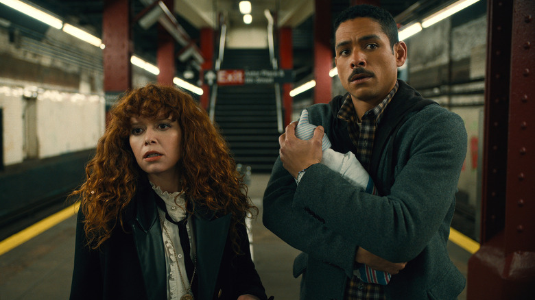 Nadia and Alan in the subway holding a baby