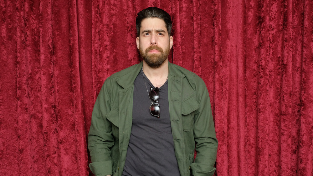 Adam Goldberg against red curtain