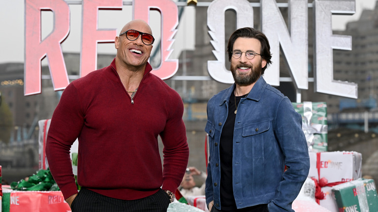 Dwayne Johnson laughs with Chris Evans at the "Red One" premiere