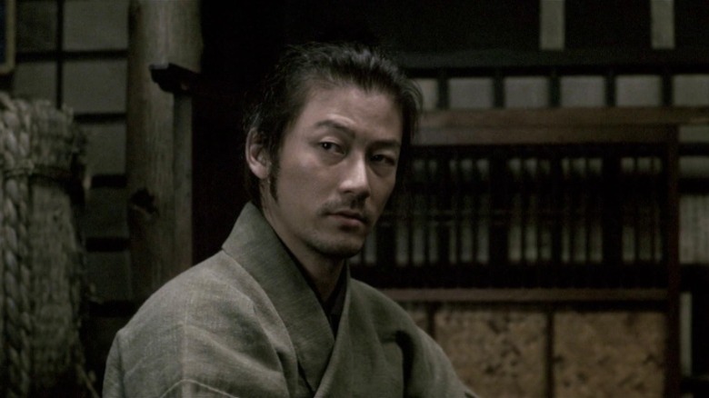 Zatoichi sits and stares pensively