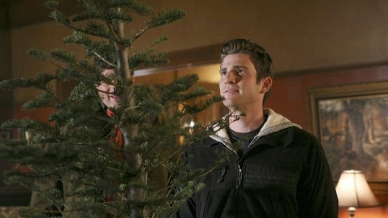 Nick looking at a Christmas tree in "October Road."