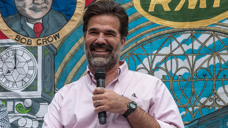 Rob Delaney holds a microphone