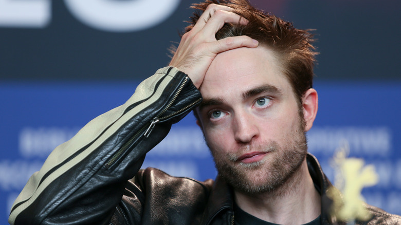 Robert Pattinson holding his head