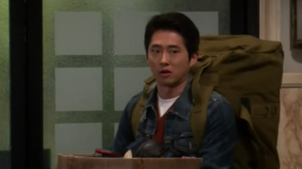 Steven Yeun with a giant backpack