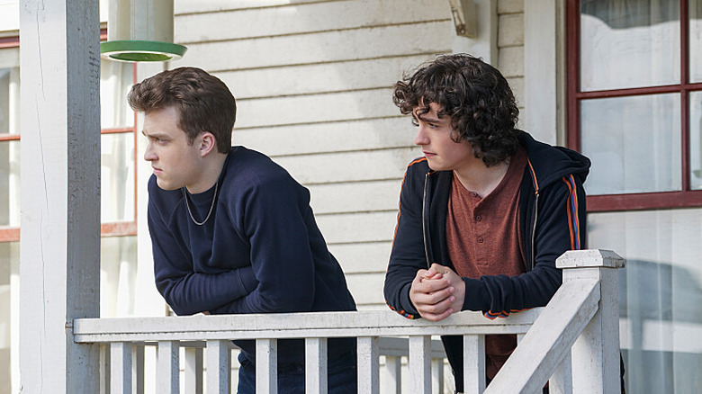 The Kent brothers leaning on a porch railing