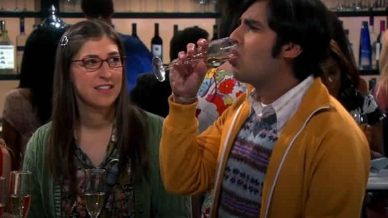 Raj Koothrappali drinks while Amy Farrah Fowler talks