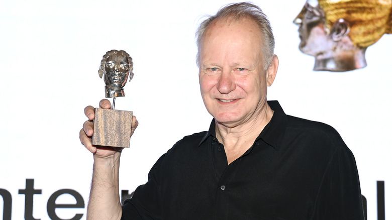 Stellan Skarsgard holding trophy