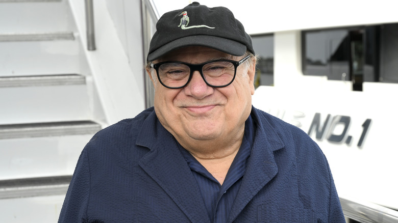 Danny DeVito wearing a black ball cap