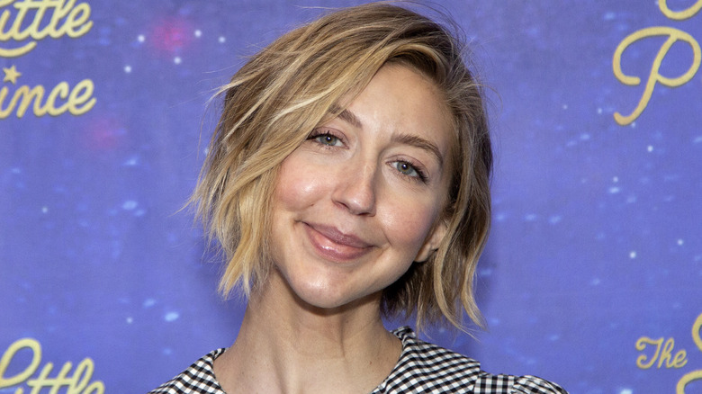 Heidi Gardner with head tilted wearing a checkered top