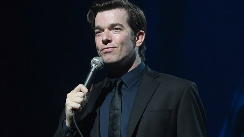 John Mulaney performing on stage