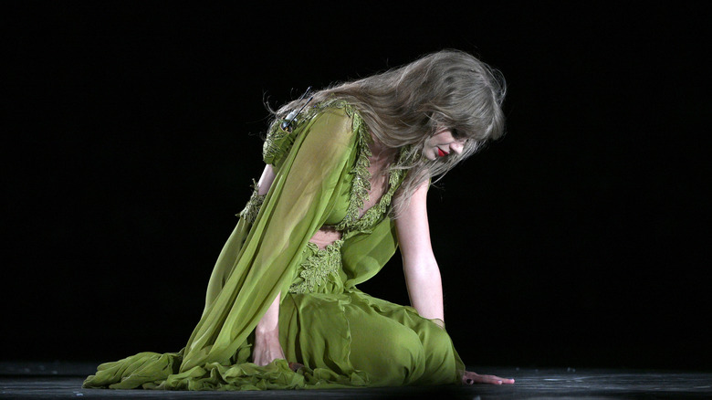 Taylor Swift kneeling on stage