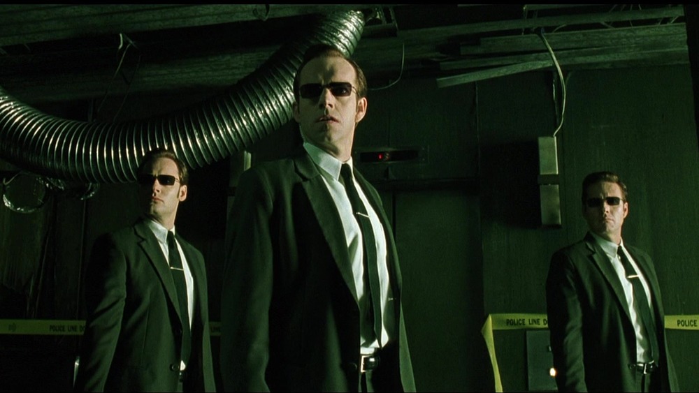 Agent Smith (Hugo Weaving) in a hallway flanked by two of his peers