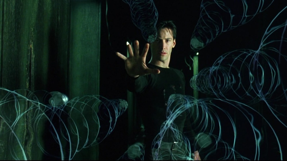 Keanu Reeves as Neo slows down bullets in The Matrix