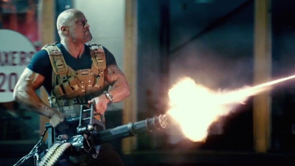 Hobbs firing a minigun in Furious 7