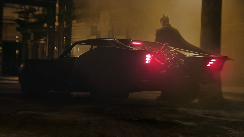 Batman with the newest iteration of the Batmobile