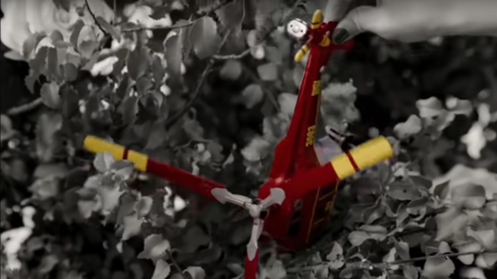 Red toy helicopter in bushes