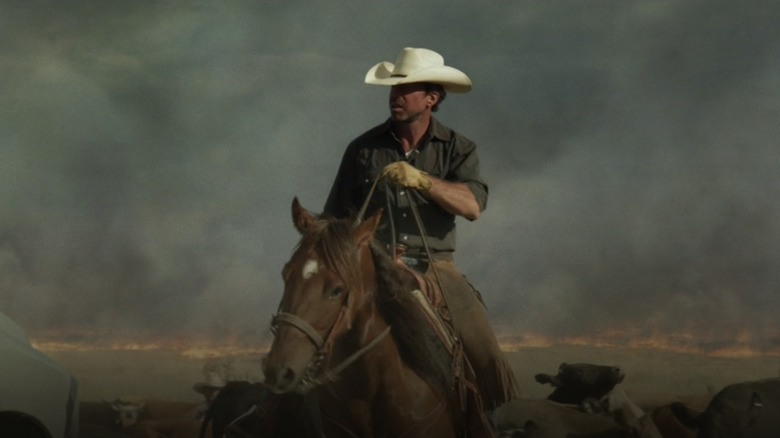 Cowboy riding away from fire Hell or High Water