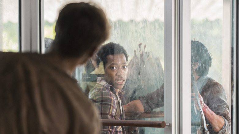 Noah looking at walkers through the glass as he and Glenn are trapped in a revolving door