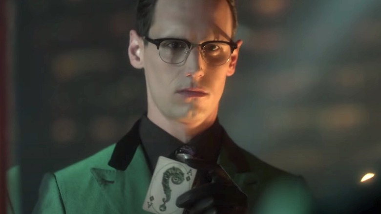 Riddler holding playing card