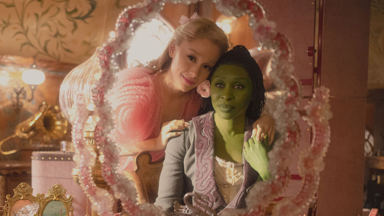 Elphaba and Galinda looking into a vanity mirror and holding hands in Wicked