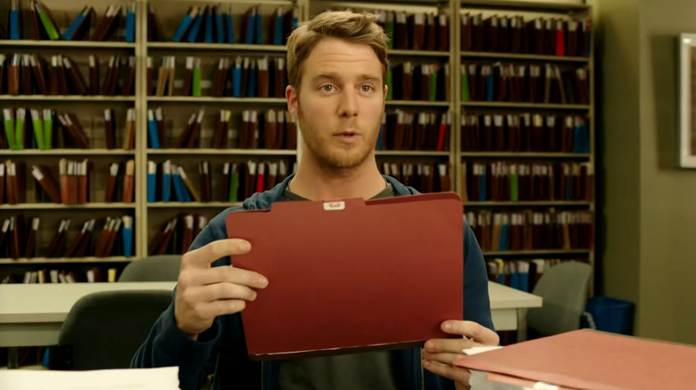 Brian Finch holding a red folder